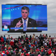 Supporters of U.S. President Donald Trump watch a video featuring Fox host Sean Hannity ahead of Trump’s arrival to a campaign rally at Oakland County International Airport on October 30, 2020 in Waterford, Michigan.